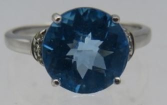 A 9ct white gold ring set with circular cushion cut topaz with three small diamond shoulders, size