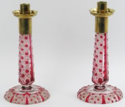 A pair of Bohemian ruby red overlaid cut glass candlesticks, late 19th/early 20th century. With