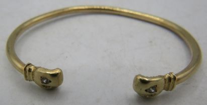 A 9ct yellow gold bangle with boxing glove terminals each set with a white stone. Approx weight 5.