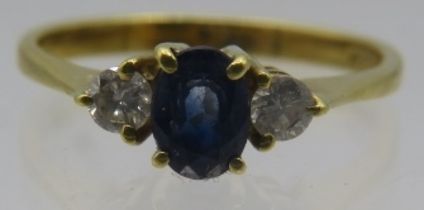 An 18ct yellow gold ring set with centre sapphire & diamonds either side. Sapphire approx 5mm x 4mm,