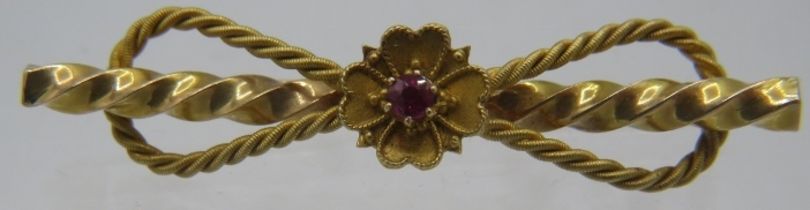 A 15ct yellow gold bar brooch with rope design & centre flower set with a small ruby. Approx