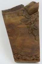 A vintage oak cheeseboard, 20th century. Relief decorated with fruit and foliage, the scroll
