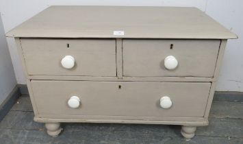 A small antique pine chest painted grey, housing two short over one long drawer with ceramic knob