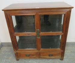 A vintage Chinese elm glazed display cabinet, having one loose shelf, above two short drawers with