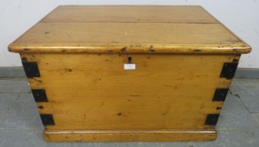 An antique pine flat topped trunk/blanket box, metal bound and having handles to with side, on a