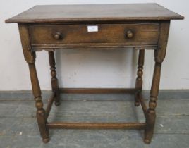 A vintage oak side table in the 18th century taste, having one long drawer with turned wooden