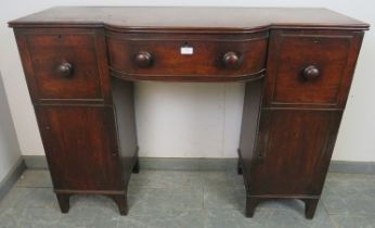 A Regency Period mahogany pedestal sideboard of small proportions, having a reeded edge above bow-