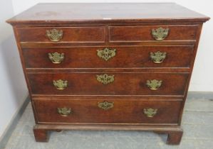 An 18th century oak chest of two short over three long graduated, cock-beaded drawers with pierced