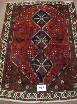 A mid 20th century Persian rug, three central linked medallions on a deep red ground, in good