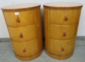 A pair of Art Deco bird’s eye maple cylindrical bedside chests, each housing three graduated drawers