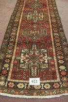 A 20th century Persian runner, seven large central motifs on a red ground. Colour and condition