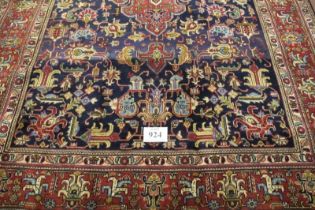 A fine Persian Tabriz carpet. Central medallion, red on blue ground, deep borders and in excellent