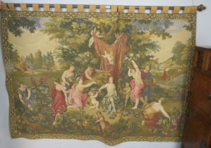 A large vintage machined wall-hanging tapestry depicting classical scenes, on a fruitwood pole