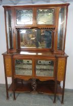 An Art Nouveau mahogany mirror-backed display cabinet, the doors with leaded lights and green