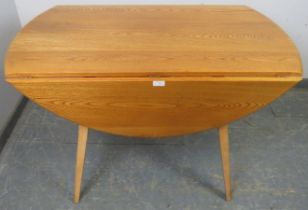 A mid-century blonde elm and beech Windsor drop-leaf dining table by Ercol (model 383), on canted