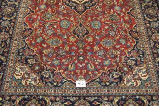 A good central Persian Kashan carpet central motif blue/cream on a floral red ground, with very wide