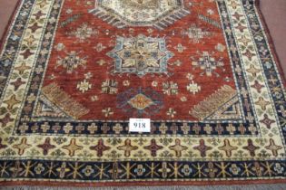 A good quality late 20th century wooley rug. One large central motif and 12 smaller on a