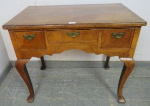 An 18th century walnut low boy, quarter veneered and crossbanded, having feather banding inlay,