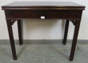 A George III mahogany turnover card table, having pierced fretwork corner decoration, on inner