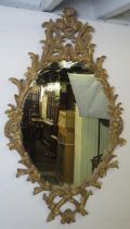 A highly decorative Georgian revival carved giltwood wall mirror, 20th century, decorated with