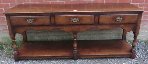 A good quality reproduction oak sideboard in the 18th century taste by Titchmarsh & Goodwin, housing