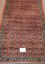 A North West Persian Bidsar runner with a central repeat pattern field on a pale red ground. 300cm x
