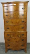 A reproduction serpentine fronted burr walnut chest on chest in the Georgian taste, having seven