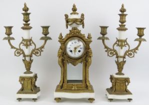 A French style gilt brass and alabaster mantel clock with matching two branch candelabra garnitures,