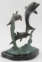 A vintage bronze sculpture depicting dolphins leaping from the water, 20th century. Naturalistically