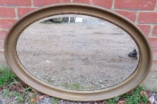 An antique oval bevelled wall mirror, within a gilt frame with reeded decoration. H62cm W88cm