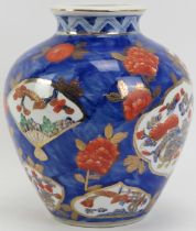 A Japanese Imari porcelain vase, 20th century. Decorated with panels and flowers against a blue