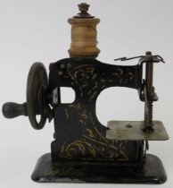 A vintage child’s miniature tinplate toy sewing machine, early 20th century. Probably German, the