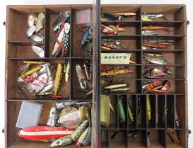 A vintage collection of fishing lures. Stored in an oak compartmented box. (Quantity). Condition