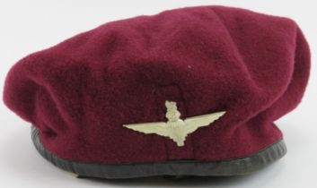 Militaria: A WWII British Airborne Forces Maroon Beret, dated 1943. With a white metal badge,