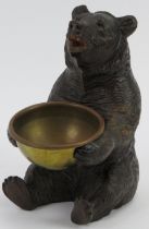A finely carved Black Forest bear holding a brass bowl. Modelled with glass eyes. Possibly to be