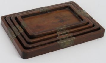 A set of four Chinese graduated rosewood trays, early 20th century. Mounted with engraved brass