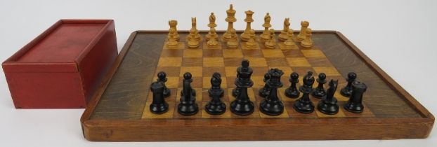 A vintage turned and ebonised holly wood chess set and a stained oak chessboard, mid/late 20th
