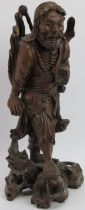 A Chinese carved bamboo figure of an Immortal, early 20th century. Modelled with inset glass eyes.