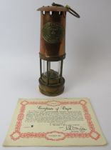 A Thomas & Williams Ltd brass and copper Cambrian miners flame safety lamp, 20th century. With a