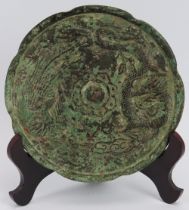 A Chinese bronze Tang dynasty style mirror. Decorated with a dragon and phoenix. Stand included.