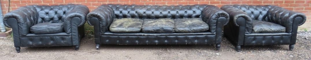 A vintage three-piece Chesterfield suite, comprising a three-seater sofa and two club armchairs,