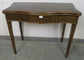 A Georgian mahogany serpentine fronted folding card table, on chamfered tapering square supports.