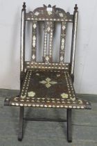 A vintage Syrian hardwood folding chair with turned finials, having profuse mother of pearl inlay,