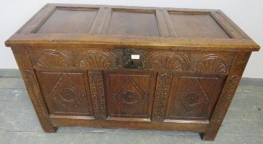 An early 18th century panelled oak coffer, having internal candle box, arcaded frieze and diamond