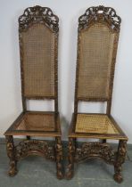 A pair of 19th century fruitwood high back bergère hall chairs in the Carolean taste, the carved and
