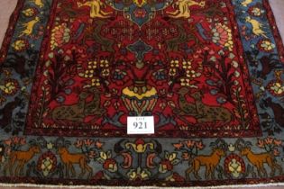 A North West Persian Nahawand rug, blue on red ground with styalised animals. 195cm x 132cm (