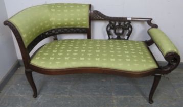 An Edwardian mahogany chaise longue of small proportions, the ornately carved and pierced backrest