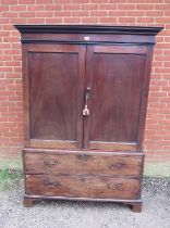 A Georgian mahogany linen press, the panelled doors opening onto loose shelves, above