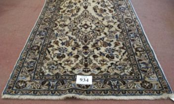 A central Persian Kashan rug. Central motif and floral design on cream ground. 180cm x 105cm (