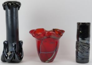 A Mdina ruby red trailed vase together with two black iridescent studio glass vases. (3 items) 27.